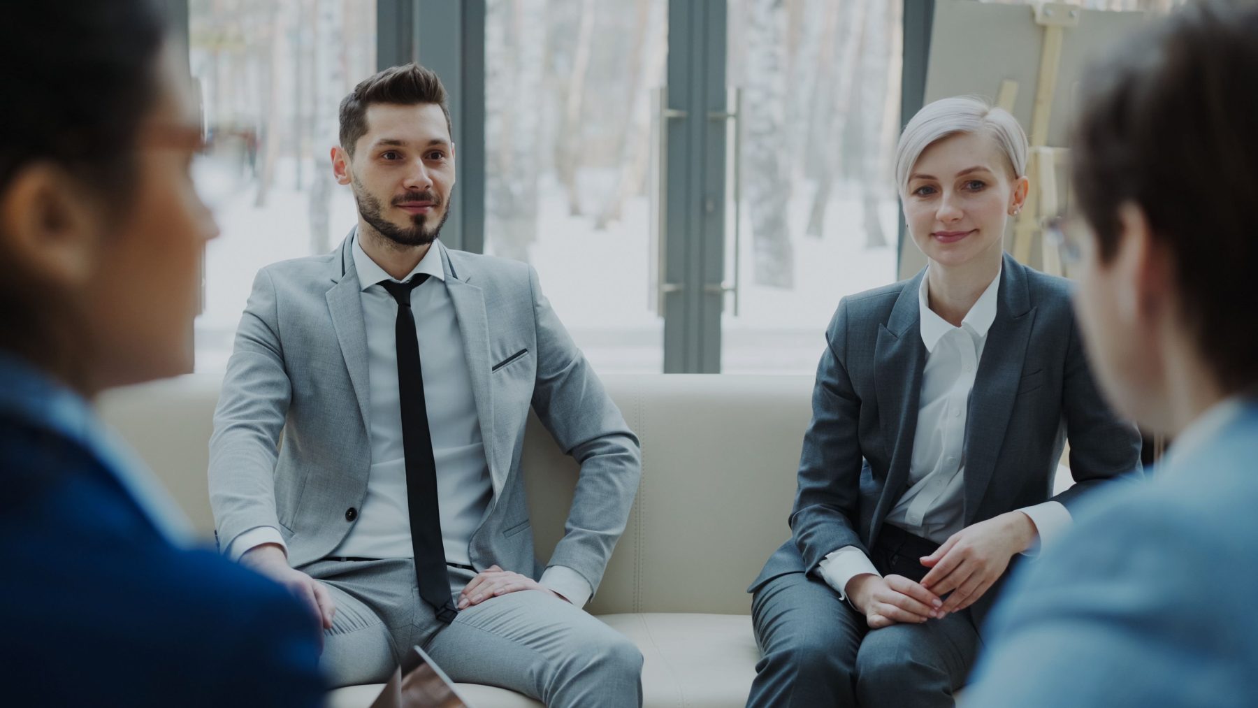 Two Homeward advisers sitting on a sofa listening to a client